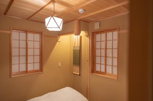 a room with two windows and a bed and a light at Saju Kyoto 茶住 京都 in Kyoto