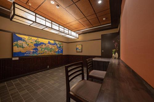 Saju Kyoto 茶住 京都 في كيوتو: قاعة اجتماعات مع طاولة وكراسي ولوحة
