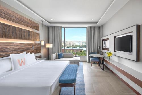 a hotel room with a large bed and a tv at Welcomhotel by ITC Hotels, Dwarka, New Delhi in New Delhi
