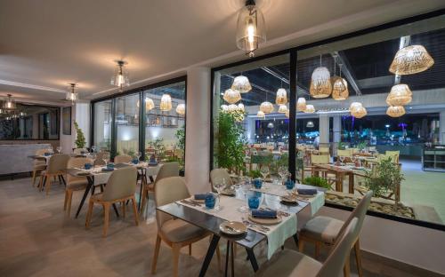 a restaurant with tables and chairs and large windows at Hilton Skanes Monastir Beach Resort in Monastir
