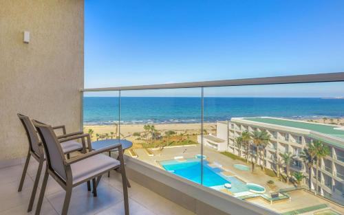 a balcony with a view of the beach and the ocean at Hilton Skanes Monastir Beach Resort in Monastir