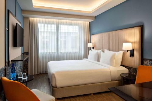 a hotel room with a large bed and a desk at Athens Key Hotel, Trademark Collection by Wyndham in Athens