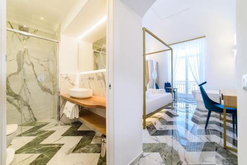 a bathroom with a sink and a toilet and a desk at Palazzo Vitagliano in Amalfi