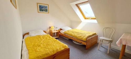 une chambre avec deux lits et une table et une fenêtre dans l'établissement Ref 094 - A louer appartement pour six vue mer proche plage du Fogeo, à Arzon