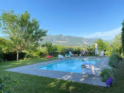 ein Pool in einem Garten mit Stühlen um ihn herum in der Unterkunft villa le Querce with private swimming pool in San Gemini