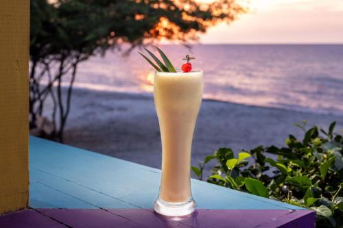a drink sitting on a table with a view of the ocean at Santa Marta Marriott Resort Playa Dormida in Santa Marta