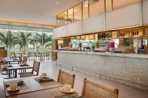 a restaurant with tables and chairs and a bar at Santa Marta Marriott Resort Playa Dormida in Santa Marta
