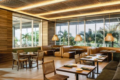a restaurant with tables and chairs and large windows at Santa Marta Marriott Resort Playa Dormida in Santa Marta