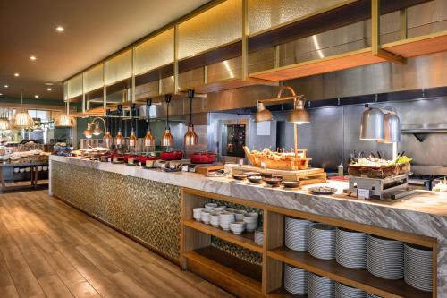 a restaurant with a counter with plates and food at Santa Marta Marriott Resort Playa Dormida in Santa Marta