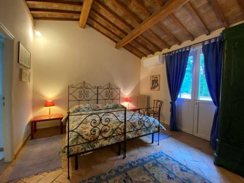 Schlafzimmer mit einem Bett und einem Fenster in der Unterkunft villa le Querce with private swimming pool in San Gemini