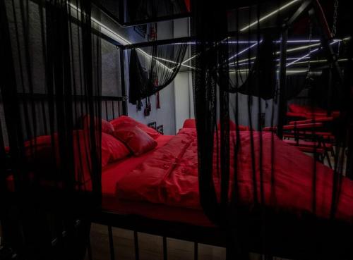 sypialnia z 2 łóżkami z czerwoną pościelą w obiekcie BDSM apartmán v Bratislave -ADULTS ONLY w Bratysławie