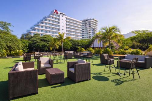 a group of chairs and tables and a building at Santa Marta Marriott Resort Playa Dormida in Santa Marta