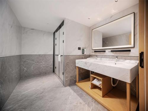 uma casa de banho com um lavatório e um espelho em Hilton Garden Inn Beijing Temple Of Heaven East Gate Station em Pequim