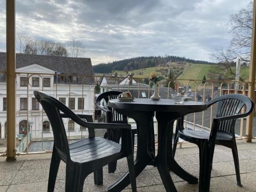 a black table and chairs on a balcony at Rathaushotel in Eibenstock
