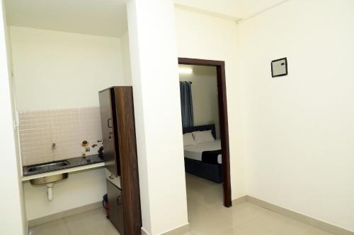 Habitación con dormitorio con cama y espejo. en Hotel Aradhya Inn Deralakatte, en Mangalore
