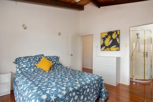 a bedroom with a blue bed with a yellow pillow at Muri Motu Outlook in Rarotonga