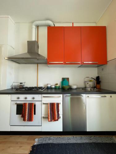 a kitchen with red cabinets and a white stove at Feriolo Nautique Apartments in Baveno