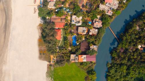 an aerial view of a group of houses next to the water at Mandrem Beach Resort, a member of Radisson Individuals Retreat in Mandrem