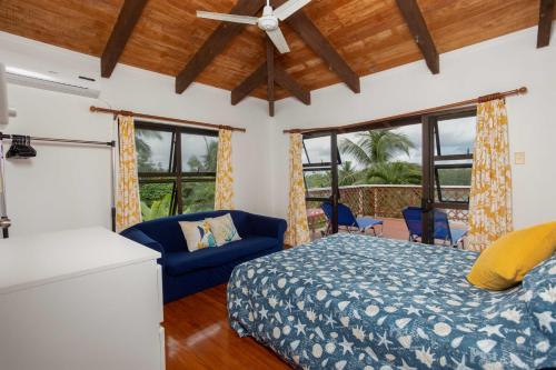 1 dormitorio con cama, sofá y ventanas en Muri Motu Outlook en Rarotonga