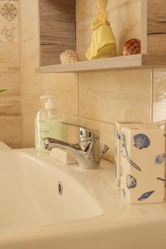 a bathroom sink with a soap dispenser on it at Aneza in Kremasti