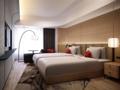 um quarto de hotel com uma cama grande com almofadas vermelhas em Novotel Nara em Nara