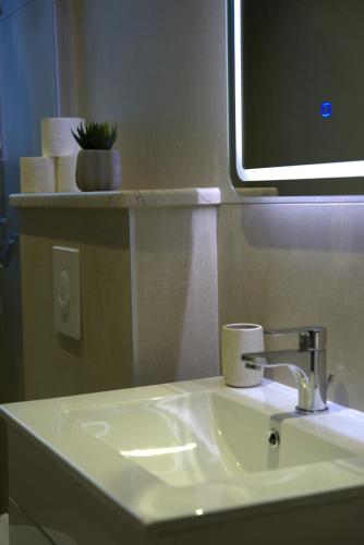 a bathroom with a sink and a tv on a wall at Boutique Hostel Livia in Metković