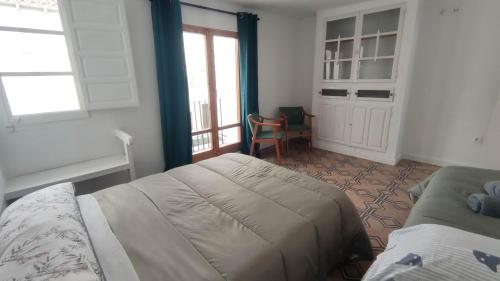 1 dormitorio con 1 cama, 1 silla y 1 ventana en Casa Lizz en Lumpiaque