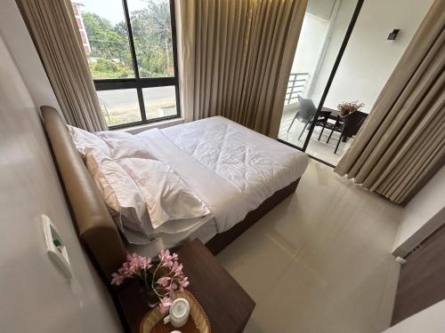 um pequeno quarto com uma cama e uma janela em The Pearl Club Resort em Santiniketan