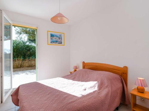 une chambre avec un lit et une porte coulissante en verre dans l'établissement Appartement T4 Rez-de-Jardin Proche Plage, Terrasse, Parking, 3 Chambres, Résidence Sécurisée - FR-1-409-224, à Narbonne