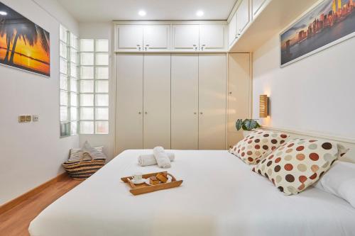 sypialnia z białym łóżkiem i tacą z ręcznikami w obiekcie BBarcelona Gràcia Nova Flat w Barcelonie