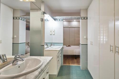 a white bathroom with a sink and a tub at BBarcelona Gràcia Nova Flat in Barcelona