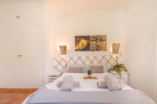 a bedroom with a large white bed with two lamps at Flores Apartments in Estepona