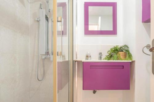 a bathroom with a purple sink and a shower at Flores Apartments in Estepona