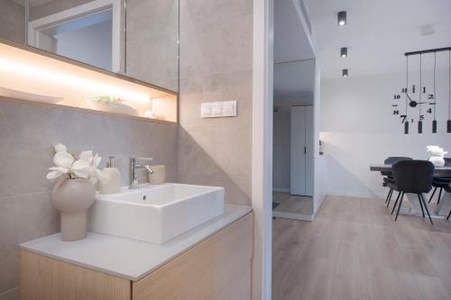 a bathroom with a white sink and a mirror at Apartament Premium PINEA 313 in Pobierowo