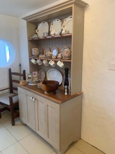 a cabinet with plates and bowls on it at Bayview, Dunmore East, County Waterford - Sleeps 12 persons in Dunmore East