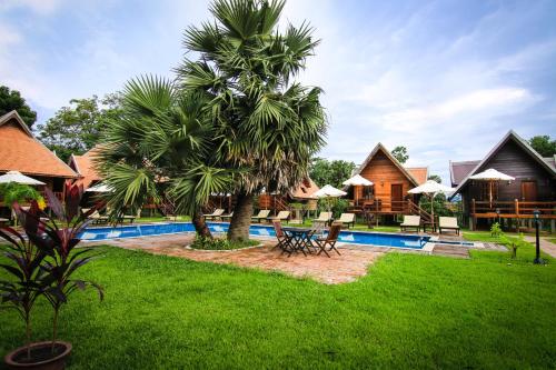 a resort with a palm tree and a swimming pool at Angkor Heart Bungalow in Siem Reap