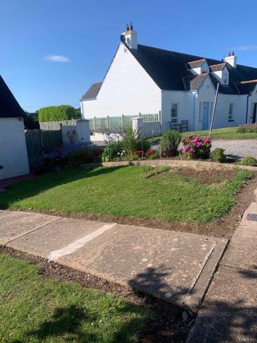 a white house with a yard and a driveway at Bayview, Dunmore East, County Waterford - Sleeps 12 persons in Dunmore East