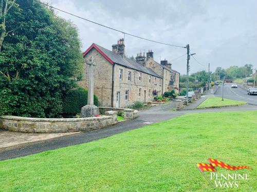 an old stone building on the side of a street at 2Fountains Cottage - Hadrian's Wall in Greenhead