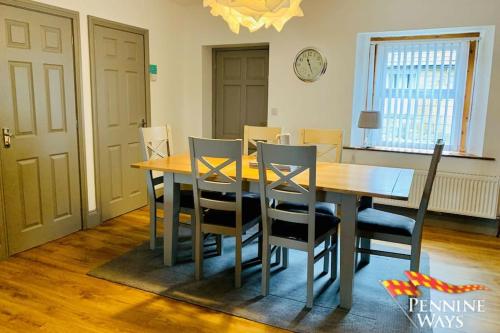 a dining room with a wooden table and chairs at 2Fountains Cottage - Hadrian's Wall in Greenhead