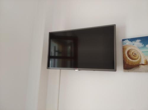 TV de pantalla plana colgada en una pared blanca en Michael Apartments, en Rethymno