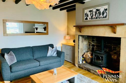 un soggiorno con un divano blu e un camino di 2Fountains Cottage - Hadrian's Wall a Greenhead