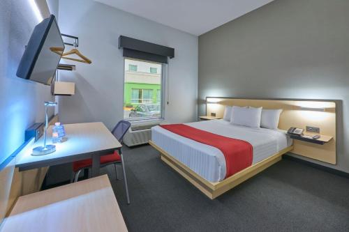 ein Hotelzimmer mit einem Bett und einem Schreibtisch mit einem Computer in der Unterkunft City Express by Marriott Toluca in Toluca de Lerdo