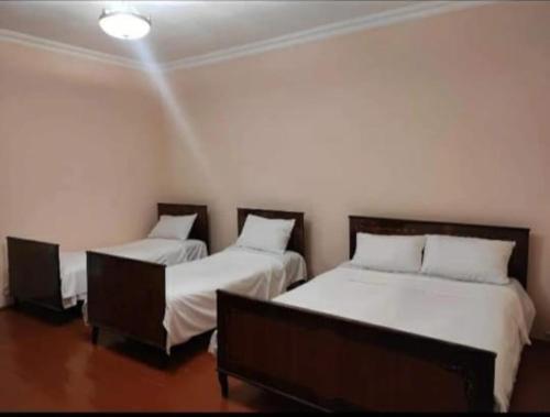 two beds in a room with white walls at MG Guest House in Ijevan