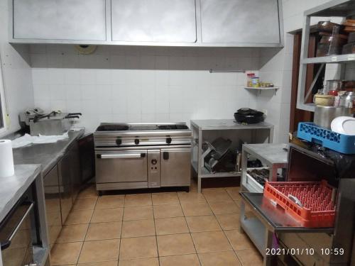 a kitchen with a stainless steel stove and cabinets at LA CASONA in Jaraiz de la Vera