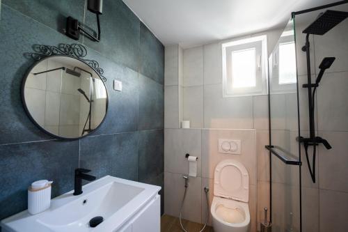 a bathroom with a sink and a toilet and a mirror at Cozy Nook in Novi Sad