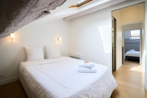 a bedroom with a large white bed with towels on it at LE BLUM COEUR - Hyper Centre Nantes in Nantes