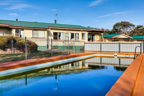 a pool of water in front of a house at Wintersun Gardens Motel in Bicheno