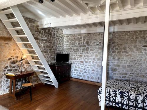a bedroom with a bed and a staircase and a desk at Le nid du coq d'or location appartement in Mont-Saint-Vincent