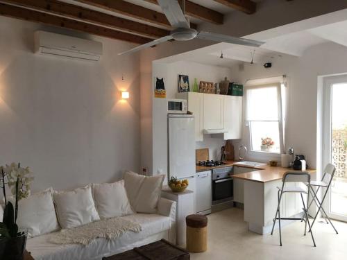 a living room with a white couch and a kitchen at casita limon in Palma de Mallorca