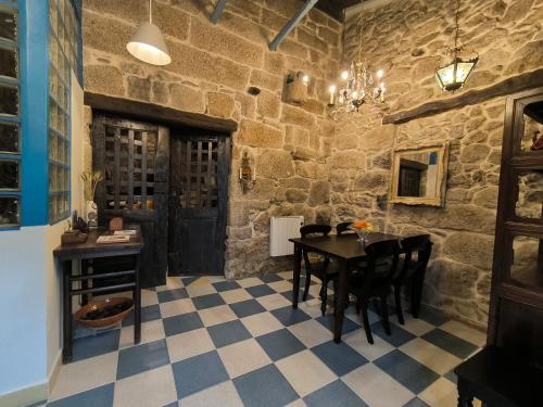 uma sala de jantar com uma mesa e uma parede de pedra em Casa Bodega Sacra em Pereiro de Aguiar